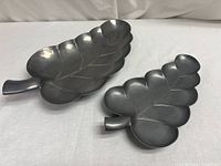 Photo of two pewter trays shaped like leaves, one larger than the other, showing their overall design and size.
