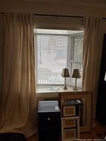 Curtain panels hanging in a window with blinds behind, showing draping and length.