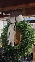 Ikea faux wreath with dense small green leaves and striped bow on top