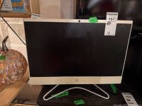 Front view of HP 21 inch monitor with black screen, beige trim, and metal stand.