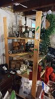 Front and side views of wooden shelving unit in basement with various items around it.