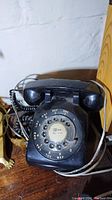 Front view of the black vintage Northern Electric rotary telephone showing the rotary dial with numbers and letters.