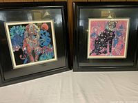 Two framed cat art prints placed side by side showing intricate colorful designs