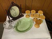 Full view of all items showing green glass tray, wooden spools, crystal candy dish, and wooden dresser frame with photo.