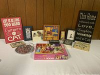 Overview of all cat-themed signs, plates, and puzzle arranged on table