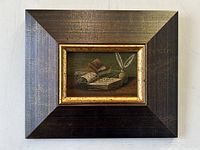 Front view of the framed oil painting showing the library table still life and frame details