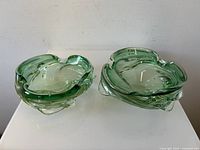 Pair of green swirled Murano glass bowls from top showing organic freeform shapes and swirls