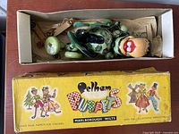 Green baby dragon string marionette puppet inside original vintage Pelham Puppets yellow box with illustrated colorful artwork and company logo Marlborough Wilts.