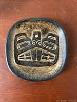 Top view of the pottery dish showing the carved Haida beaver design in brown glaze.