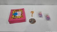 Barbie pink clothes case, hair comb, collector pin, two small figurines