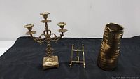 Brass candleabra, easel stand, and amorphic brass vase from side view