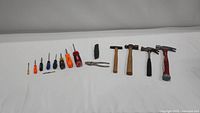 Entire collection of small hand tools arranged in a line on white surface showing all included items