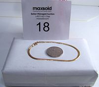 Bracelet displayed with a coin and lot card for overall view and scale