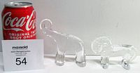 Photo of two clear crystal paperweights, an elephant and a lion, next to a Coca-Cola can for size reference.