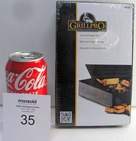 Photo showing the front of the sealed Grillpro cast iron smoker box packaging next to a soda can for size reference.