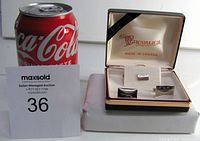Photo showing the cuff links and tie tack pin in original presentation box beside a can for size reference.