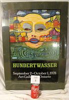 Poster displayed upright with black board mount showing the full colorful daytime artwork, title, artist name, and exhibition details.