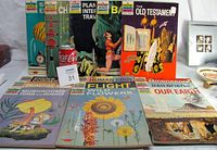 Photo showing all 14 How and Why Wonder vintage books arranged standing and lying flat with cover artwork visible, highlighting various subjects.