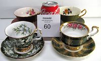 Photo showing four teacups with matching saucers arranged with a Coca-Cola can for scale: includes floral and gold trim details, all in excellent condition.
