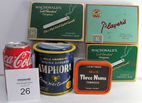 Five vintage tobacco and cigarette tins shown with a Coca-Cola can for scale, including 3 MacDonald's cigarette tins, 1 Player's cigarette tin, 1 Amphora tobacco tin, and 1 Bell's Three Nuns tobacco tin. All tins have original tariff labels visible on some items.