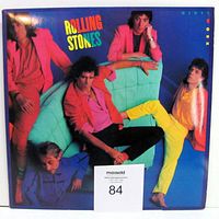Front cover of the Rolling Stones Dirty Work album showing the band members on a green couch in colorful clothing.