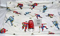 Full view of the vintage NHL bed sheet laid out with a Coca-Cola can for scale. Shows multiple hockey players in Toronto Maple Leafs and Montreal Canadiens uniforms.