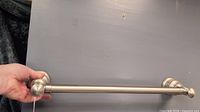Photo of one brushed nickel towel bar showing length and mounting detail.