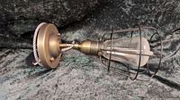 Photo of antique brass semi flush mount ceiling light fixture with metal cage shade.