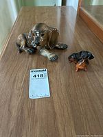 Photo showing both dog figurines on a wood surface with size labels visible.
