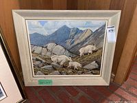 Front view of framed painting leaning against wood panel wall