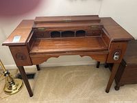 Open view of the vintage wood secretary desk showing the hinged top opened revealing cubbies and small drawers inside.
