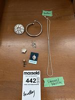 Full lot of sterling silver jewelry displayed on wood surface with two green notes note that necklace clasp is broken and one piece stamped sterling.