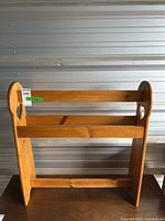 Full view of wood blanket stand with horizontal bars and heart cutout designs on each side.