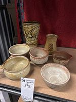 Front view of entire set featuring five ceramic bowls, one tall textured ceramic vase, and one small pitcher