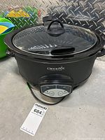 Full view of black Crock-Pot slow cooker with glass lid showing overall condition and design