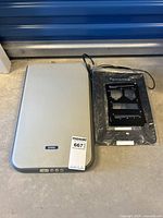 Photo of the Epson Perfection 1260 scanner and photo scanning frames placed side-by-side on concrete floor.