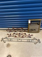 All items together showing two metal leaf wall decor pieces, a wrought iron wall hook rack, and a gold framed mirror