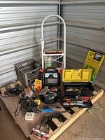 Image showing the SKIL power drill, Mouse sander, Stanley toolbox open with assorted tools visible, white metal stepladder, clamps, and other tools arranged on a cardboard-covered wooden pallet.