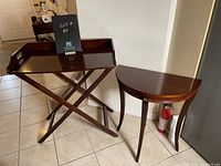 Photo showing both the half moon occasional table and the butler serving table side by side on tiled floor.