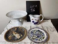 Photo showing all four items: white cake tray, Royal Worcester jug, Rhodes blue and white plate, Norman Rockwell collector's plate