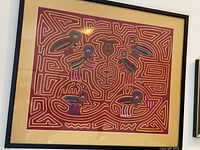 Front view of framed tapestry showing detailed labyrinth pattern with multiple animal figures in multicolor threads and black frame.