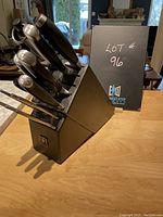 Photo of Henckels knife set in black butcher block holder from front angle showing knives and sharpening steel