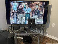 TV on stand showing screen on and stand structure