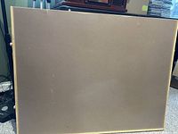 Front view of wooden framed puzzle board with smooth surface.