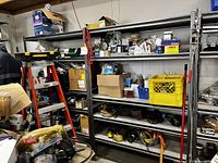 Wide view of two metal shelving units installed in workspace with assorted items