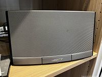 Front view of the Bose SoundDock Portable speaker showing the silver grille and Bose logo.