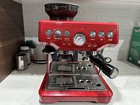 Front view showing control panel, analog pressure gauge, portafilter in place and filled bean hopper