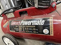 Close-up of side label showing brand, tank size, horsepower and CFM ratings