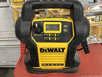 Front view of DeWalt jump starter showing controls, LCD display, USB ports, and branding