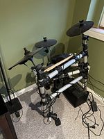 Front view of assembled electronic drum kit showing pads, cymbals, module, and frame